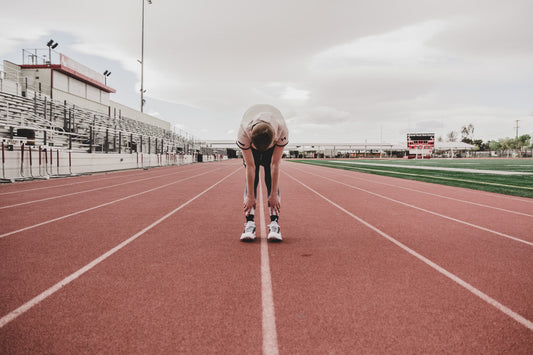 Athlete stretching on a running track with several marked lanes